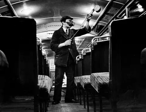 Getty Images Man spraying bus with anti-flu