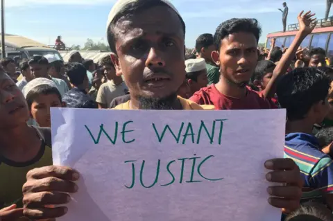 Rohingya protester in Cox's Bazar holds up placard demanding justice