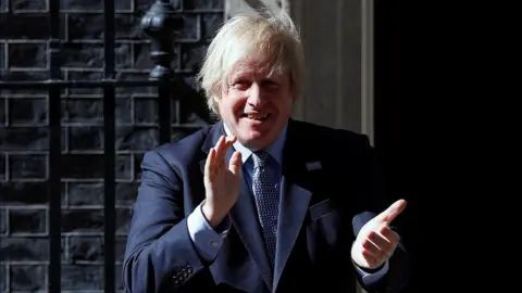 Reuters Prime Minister Boris Johnson took part in the clap from outside Downing Street