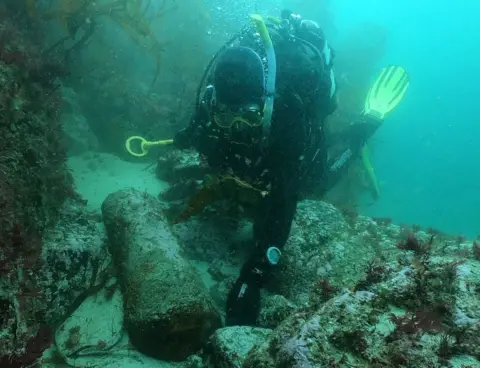 Ben Dunstan Diver David Gibbins with a cannon on the wreck site in 2021