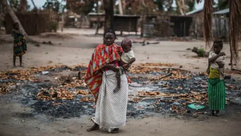 Getty Images Woman and child amid burned buildings