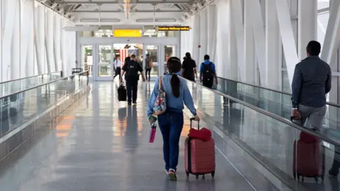 Getty Images People head towards departures at John F Kennedy Airport in 2016