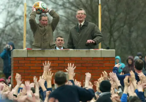 PA Media Prince Charles prepares to "turn up" the ceremonial ball before starting the ancient Royal Shrovetide Football game, in Ashbourne, Derbyshire
