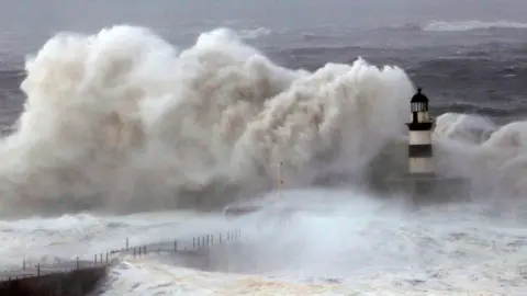 Reuters Huge waves crash against the pier wall at Seaham Lighthouse during Storm Arwen, in Seaham, County Durham