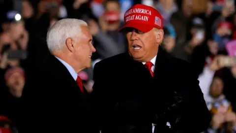 Reuters US President Donald Trump talks to Vice President Mike Pence, as he holds a campaign rally at Gerald R. Ford International Airport in Grand Rapids, Michigan, US on 2 November 2020