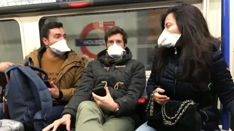 PA Media People on a tube wearing face masks