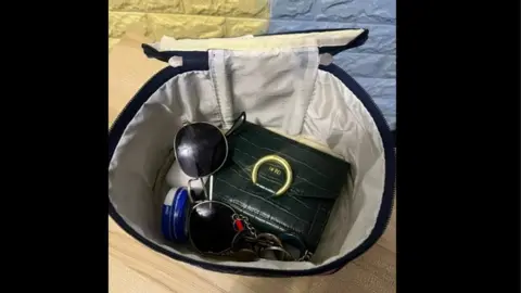 Rach Idowu The inside of Rach's Important Box which includes a purse and sunglasses