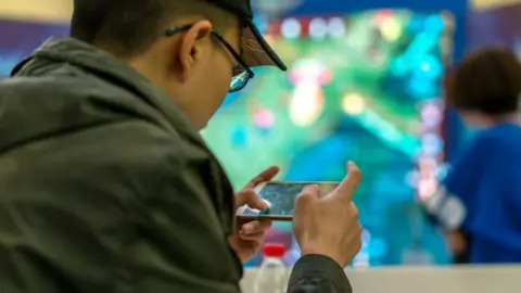 Getty Images Gamer on mobile phone