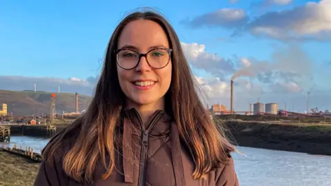 Ffion Lloyd-Jones on Aberavon beach, with the steelworks in the background