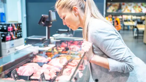 Getty Images Woman looking at pork