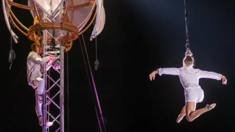 Freedom Festival A woman being suspended from a cable