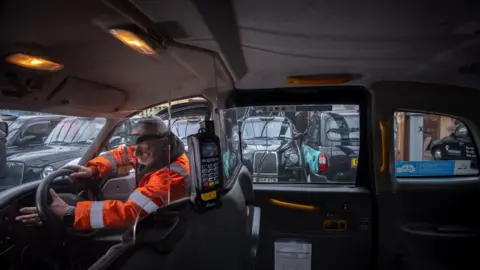 PA Media An engineer works on a de-licensed black cab in a yard at Sherbet London in east London