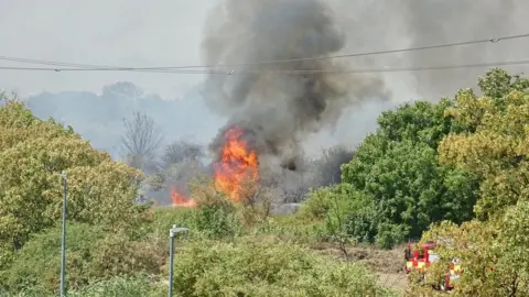 PA Media Firefighters attend a fire on Dartford Marshes