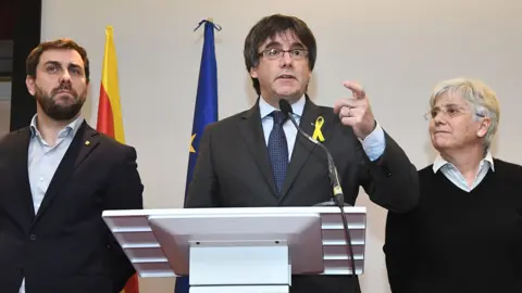 AFP Carles Puigdemont (C) with allies Clara Ponsatí (R) and Antoni Comín in Brussels, 6 Dec 17