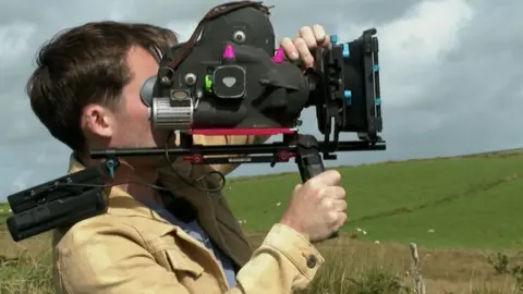 BBC Guy Potter holding a camera