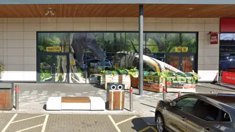 Google Front facade of the Jurassic Grill at Rushden Lakes, showing large picture of dinosaur in a forest