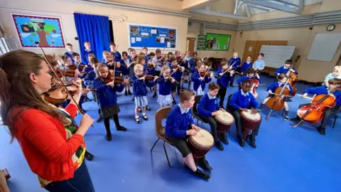 Martin Giles/BBC Children playing musical instruments