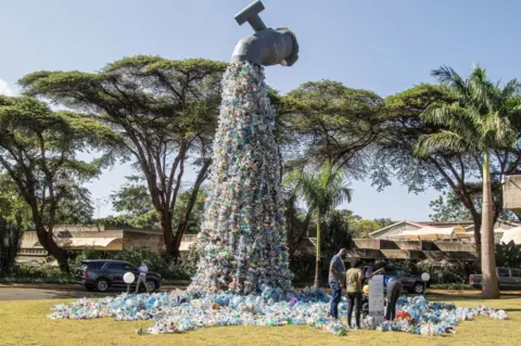 Getty Images People are seen next to a plastic waste art installation by Canadian activist and artist, Benjamin von Wong on display outside the United Nations Environment Programme headquarters in Nairobi during UNEA conference. United Nations Environmental Assembly the world's foremost environmental decision-making body kicked off yesterday with opening remarks by its president Espen Barth Eide who reiterated for a multilateral action to end plastic pollution. Rwanda and Peru had proposed a legally binding draft resolution with a plastic full life cycle approach.