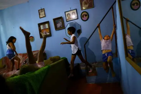 Jose Luis Gonzalez / Reuters Girls from the Rodriguez family play in their home