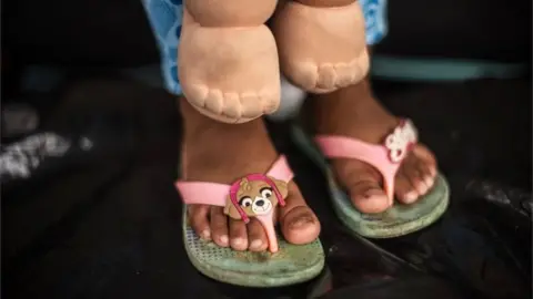 AFP A migrant child in her flip-flops.