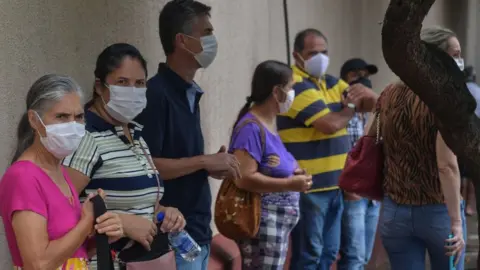 Nelson Almeida/Getty Residents line up to receive the Coronavac vaccine against COVID-19, in Serrana