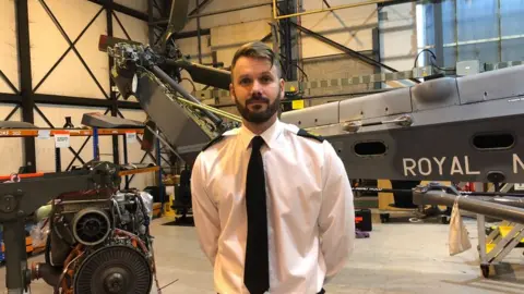 Man stood in front of helicopter