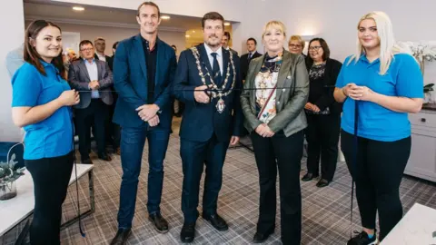 LIAM GILMAN Andrew Cowie cutting the ribbon to open the building