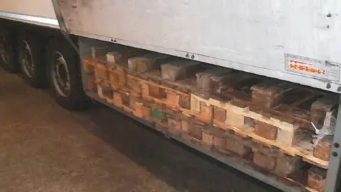 National Crime Agency A lorry with pallets hidden underneath concealing drugs