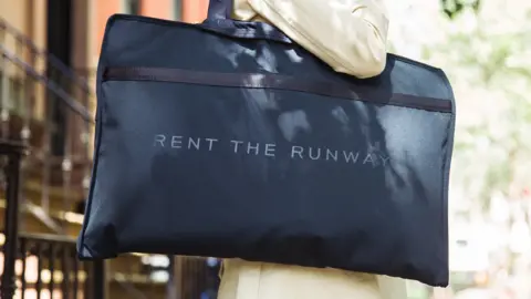 Rent the Runway Woman carrying bag with Rent the Runway logo