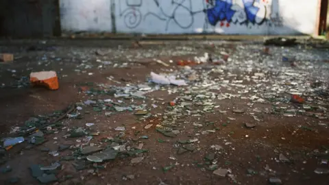 Getty Images Broken glass and graffiti on wall