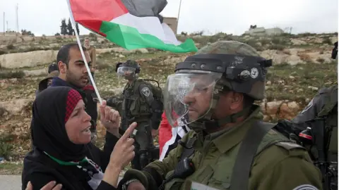 Reuters Palestinian woman confronts Israeli soldier in the West Bank (file photo)