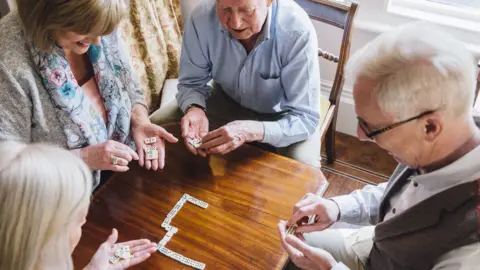 Getty Images Group of elderly people playing dominoes