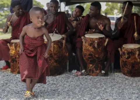 EPA A boy dances as drummers in traditional dress perform at the Accra International Conference centre where the body of the late Kofi Annan has been laid in state in Accra, Ghana, 11 September 2018