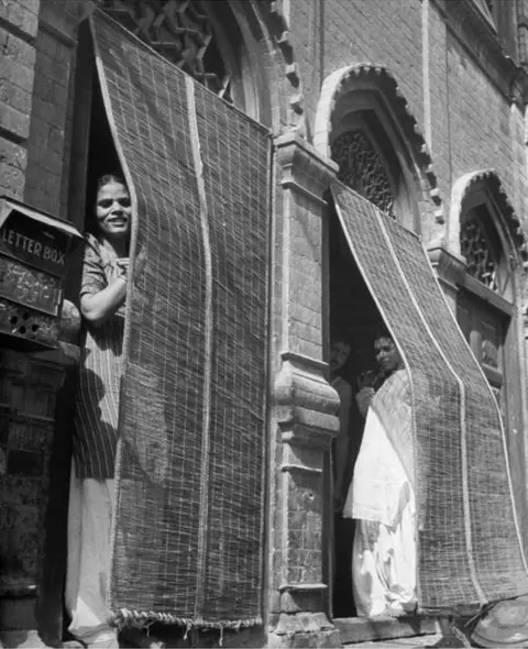 Margaret Bourke-White/Getty Images 946: Indian prostitutes peeking out fr. doorways of their brothel