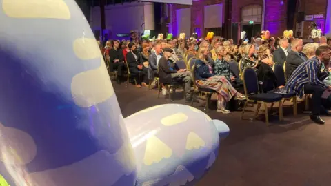 BBC The nose of a Swindog looking on to a seated crowd of hundred at Swindon's STEAM Museum