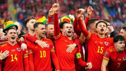 PA Media Gareth Bale celebrates with team-mates after Wales qualified for its first World Cup since 1958