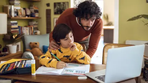 Getty Images Father helping his son with schoolwork