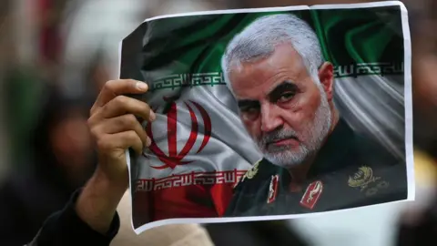 Reuters An Iranian holds up a picture of Qasem Soleimani in Tehran, Iran, on 4 January 2020