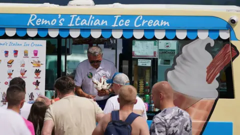 PA Media People queuing for ice cream at Loch Lomond, in the village of Luss in Argyll and Bute, Scotland