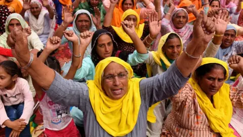 Getty Images Farmers shout slogans as they take part in a protest against the central government's recent agricultural reforms on the outskirts of Amritsar on April 19, 2021.