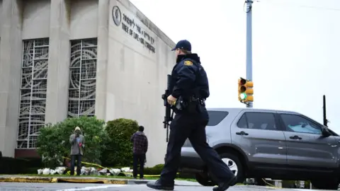 Getty Images An American police officer crosses the street outside the Tree of Life Synagogue, where 11 people were killed by a right-wing extremist.