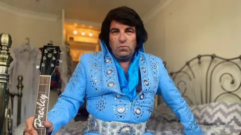 We follow a former bus controller as he tries to become a full-time Elvis tribute act.