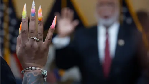 Getty Images Ms Moss raises her hand to be sworn in by the commitee