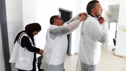 EPA Medics putting on protective gear in Tunis, Tunisia - Tuesday 7 April 2020