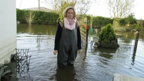 Maria and Phil Maye Women stood in overalls with water knee-deep high