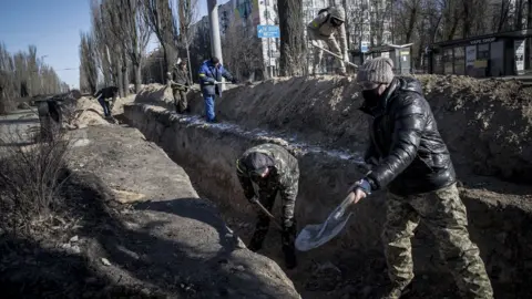 Getty Images Trenches are prepared by the side of the road in Kyiv, 10 March 2022.