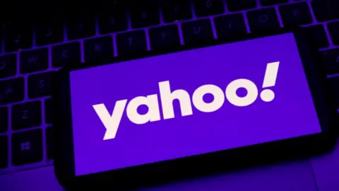 Getty Images Yahoo logo on a smartphone, resting on a keyboard