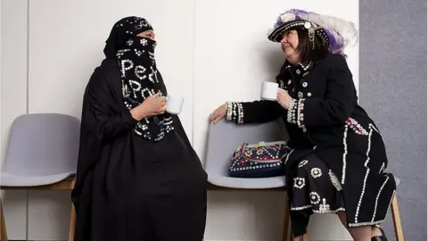 Cockney Cultures Two women wearing modern versions of the traditional Pearly Queen outfits