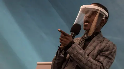 Prophet Paseka Motsoeneng, popularly known as Prophet Mboro, wears a face mask as he celebrates inside the Incredible Happenings Ministry Church, in Katlehong, Ekurhuleni on June 07, 2020. - Rigid distancing, hand sanitising and record keeping was enforced today at the church, where only 50 worshippers have been admitted in observance to South Africa lockdown level 3 regulations.