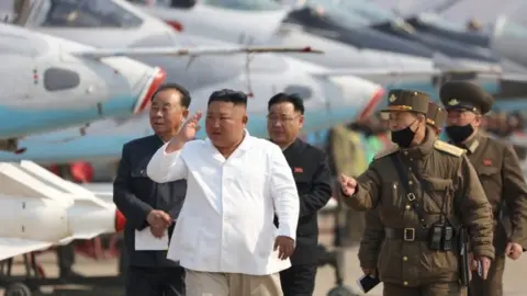 EPA Kim Jong-un (centre) inspects North Korea's Air Force units on 12 April 2020